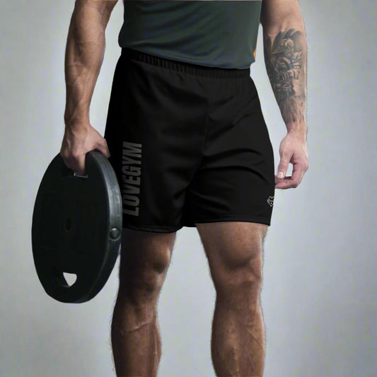 Person wearing black shorts with 'LOVEGYM' branding in a gym setting